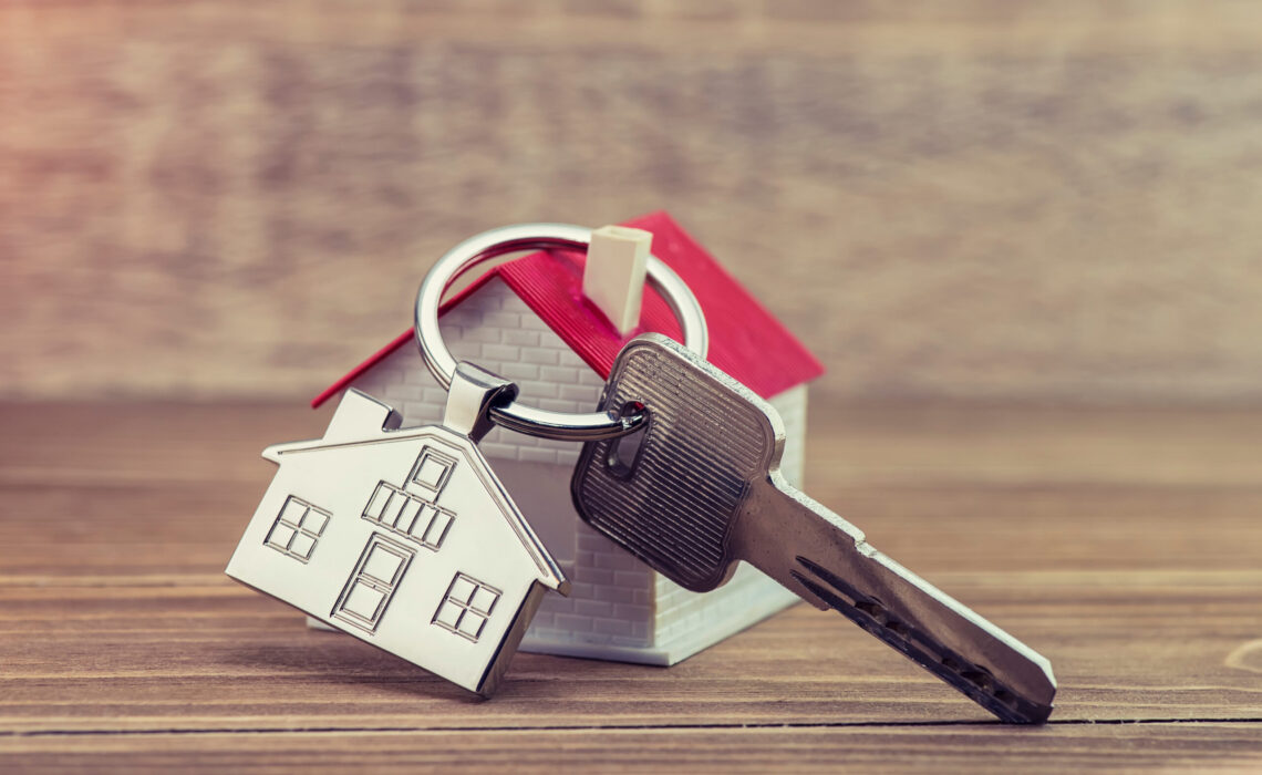 Key Chain With House Symbol And Keys On Wooden Background,real E