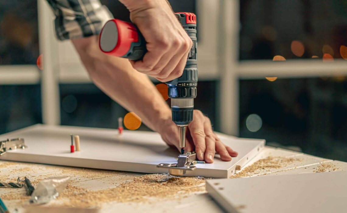 rhywun yn drilio ar bren haenog