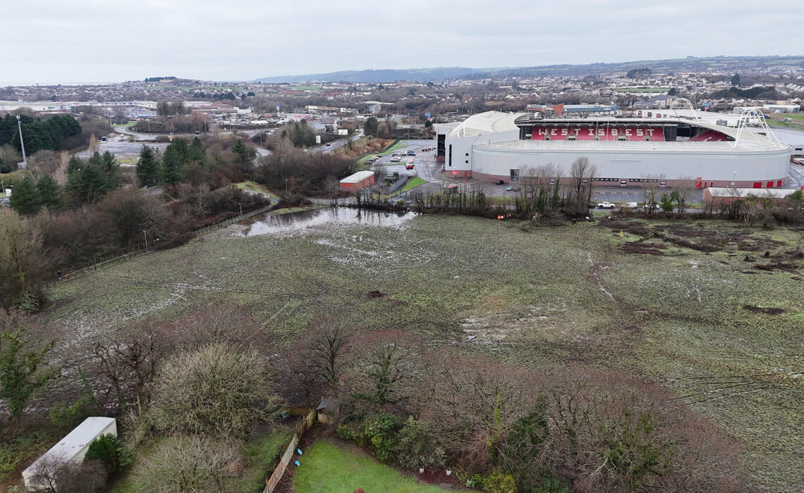Golygfa o'r awyr o safle adeiladu yn Llwynhendy gyda Pharc y Scarlets a Throstre yn y cefndir