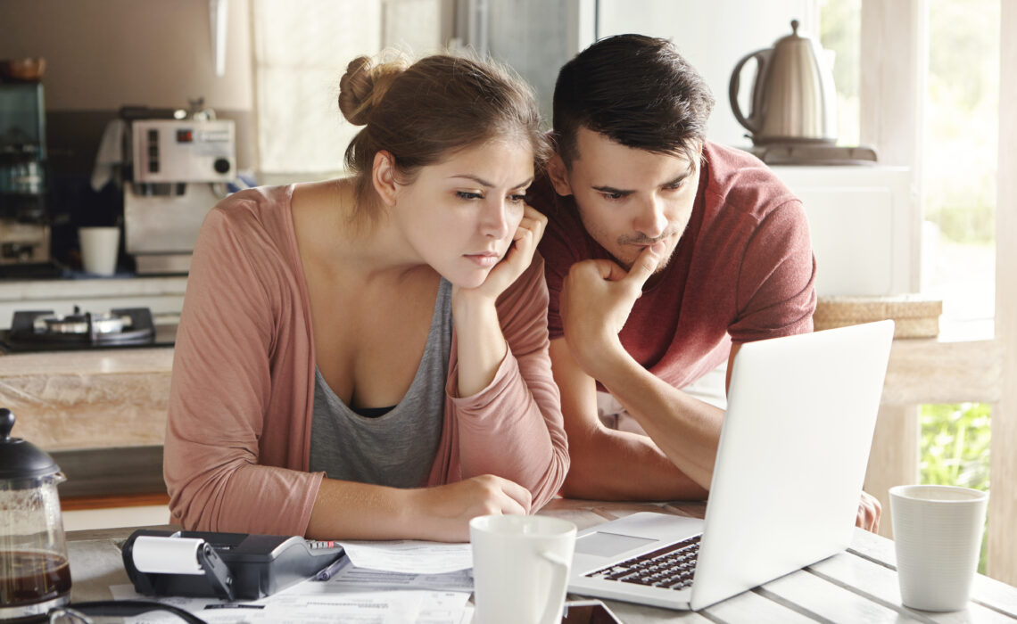 Dyn a Menyw Ifanc yn edrych ar liniadur gyda'i gilydd