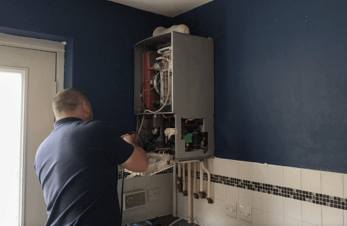 Gas engineer working on a boiler in a home