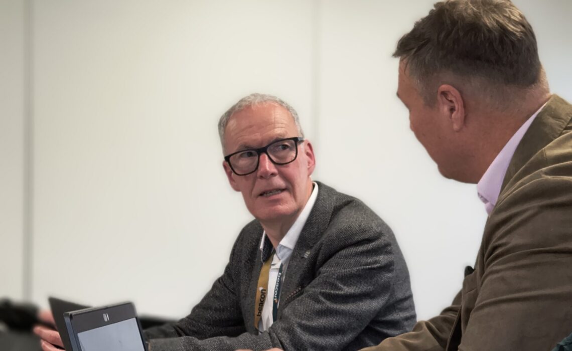 Peter Hughes chair of board talking to another board member