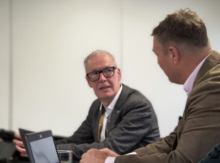 Peter Hughes chair of board talking to another board member