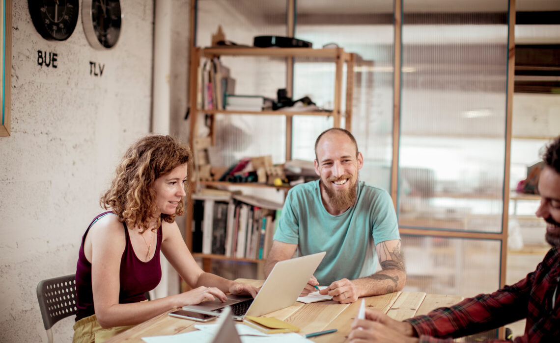 Man smiling at people around a table