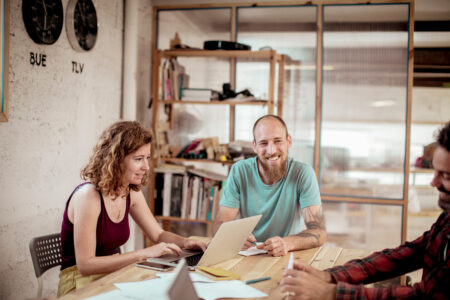 Man smiling at people around a table