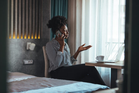 Woman talking on the phone in her home looking unhappy