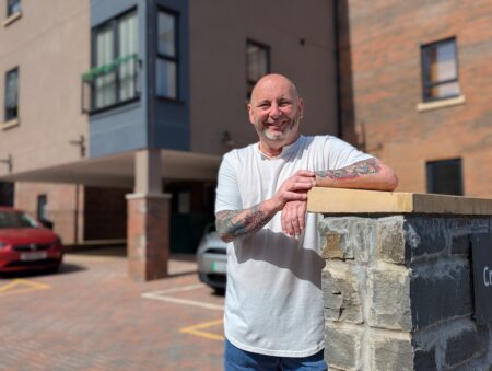 Resident of Beacon standing outside a home smiling