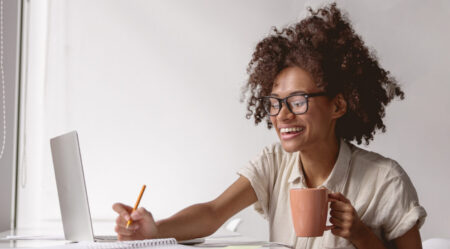 Joyful Young Woman In Glasses Writing Down Notes