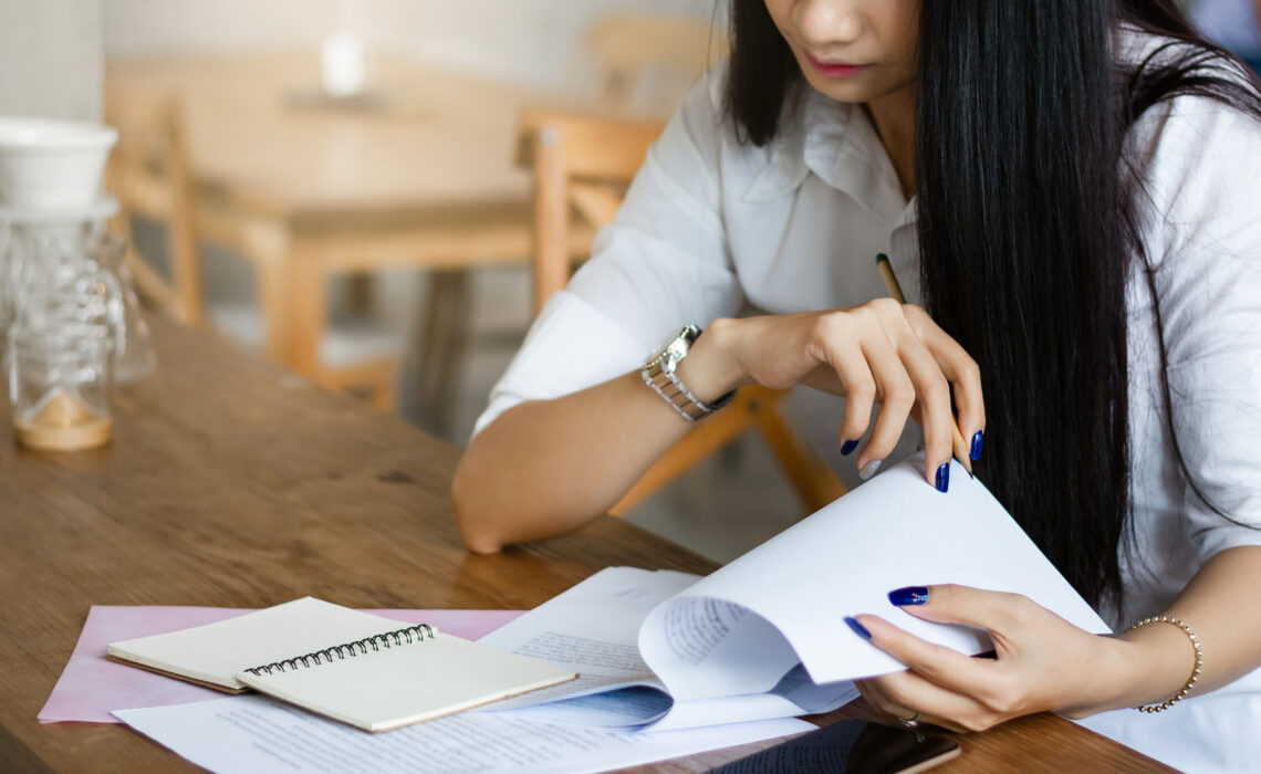 Woman looking at paper work sat at a kitchen bench